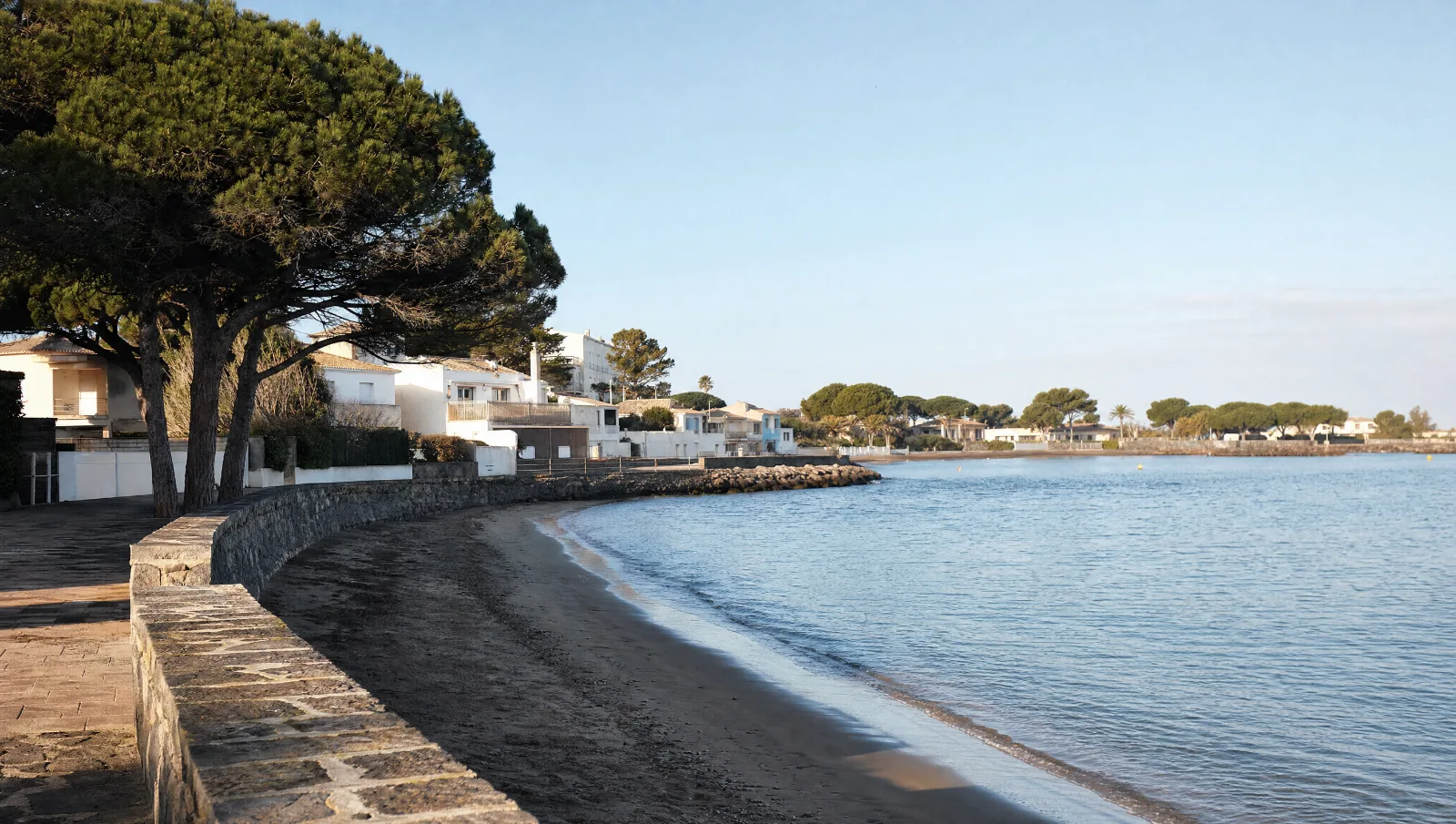 Promenade en bord de mer près d'Agde le matin, mer calme, bâtiments bas et pins (illustration)